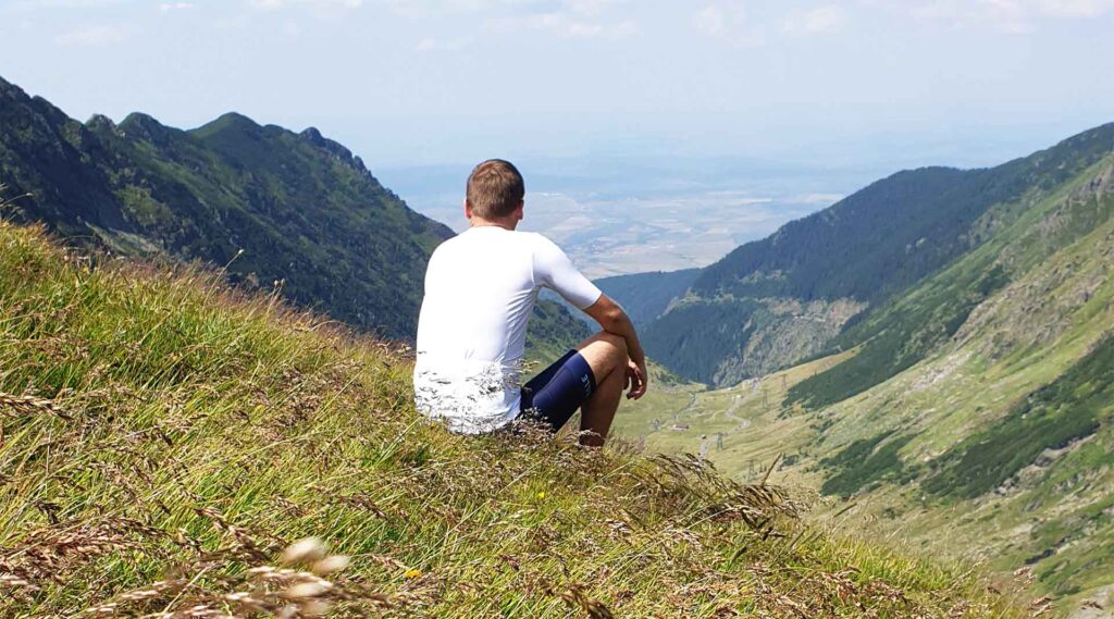 Sportswear of Tomorrow. Athlete sitting in the mountains with cycling wear made of recycled fishing nets and plastic bottles